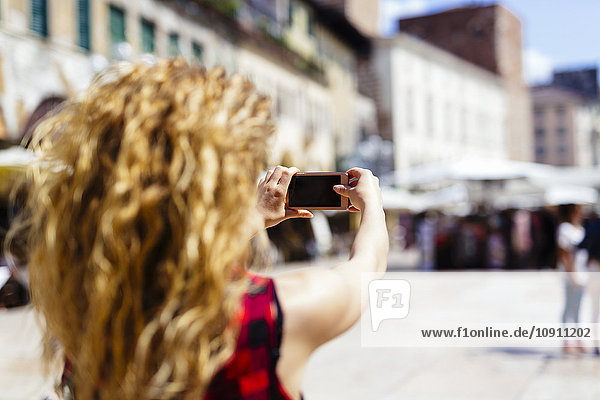 Italien  Verona  Frau macht ein Handyfoto in der Stadt