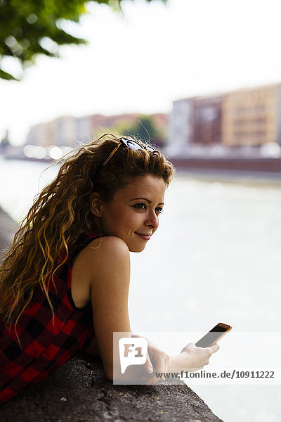 Italien  Verona  Frau am Flussufer mit Handy