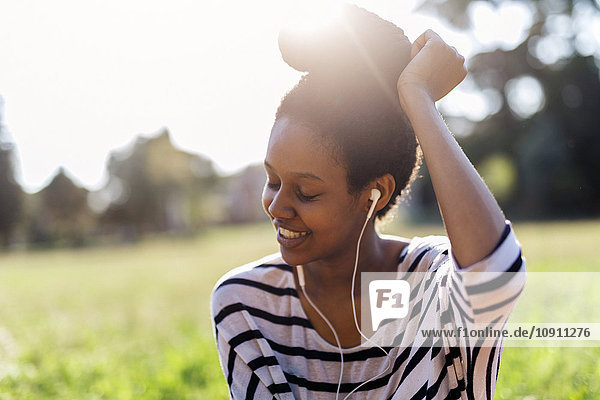 Lächelnde Frau hört Musik mit Kopfhörern