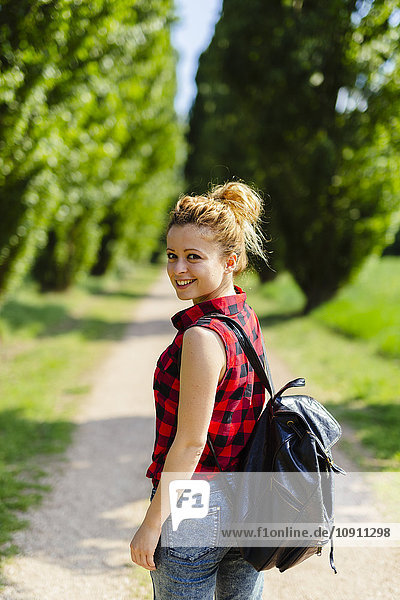 Portrait of smiling woman with backpack in nature