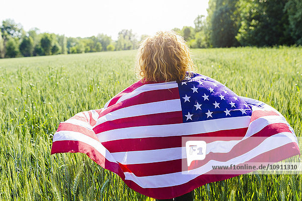 Rückansicht der Frau mit amerikanischer Flagge in der Natur