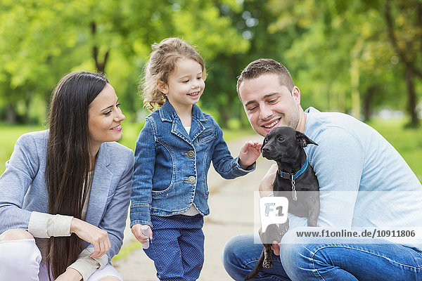 Glückliche Familie mit Hund im Park