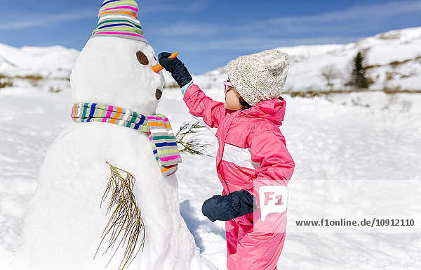 Spanien  Asturien  Mädchen beim Schneemännerbau im Winter