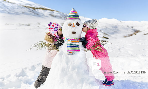 Spain  Asturias  kids playing with snowmen  kissing