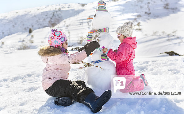 Spain  Asturias  kids playing with snowmen in a snowy mountains