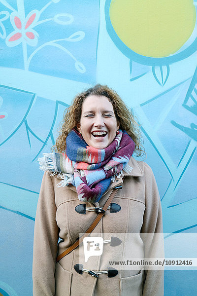 Frau lacht  Graffiti im Hintergrund