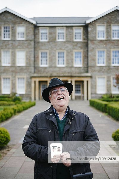 UK  Bristol  Porträt eines lachenden älteren Mannes mit schwarzem Hut