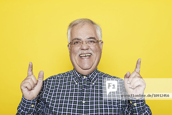 Porträt eines lachenden älteren Mannes vor gelbem Hintergrund