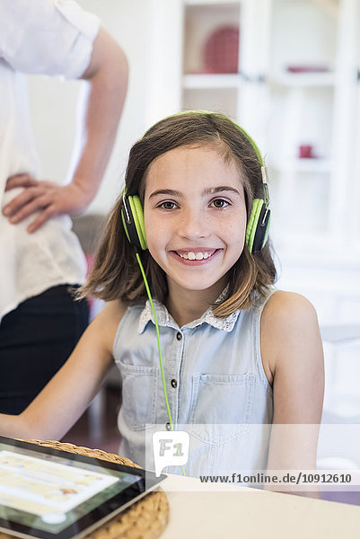 Porträt eines lächelnden Mädchens mit digitalem Tablett und Kopfhörer