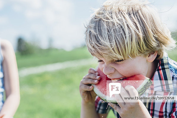 Junge im Freien essen Scheibe Wassermelone