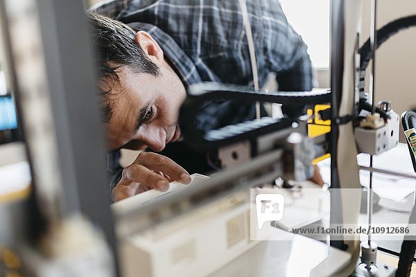 Worker controlling a model  3D printer