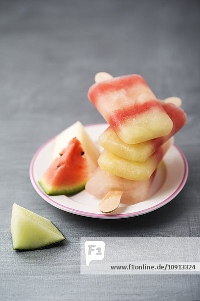 Teller mit Stapel von verschiedenen hausgemachten Melonen-Eis-Lollies