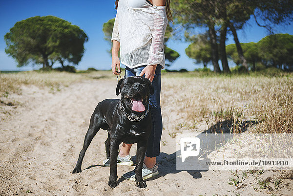 Frau mit ihrem Hund in ländlicher Landschaft