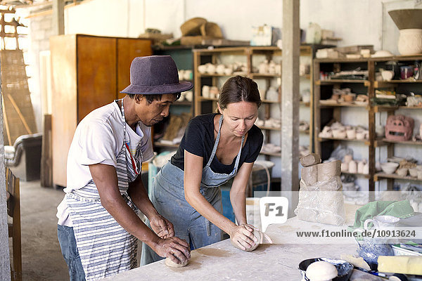 Man and woman in workshop working on pottery