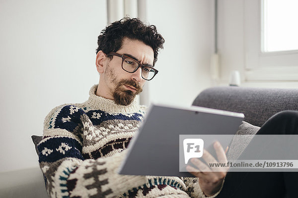 Porträt eines nachdenklichen Mannes mit digitalem Tablett