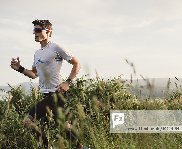Trail runner man training in nature in the evening
