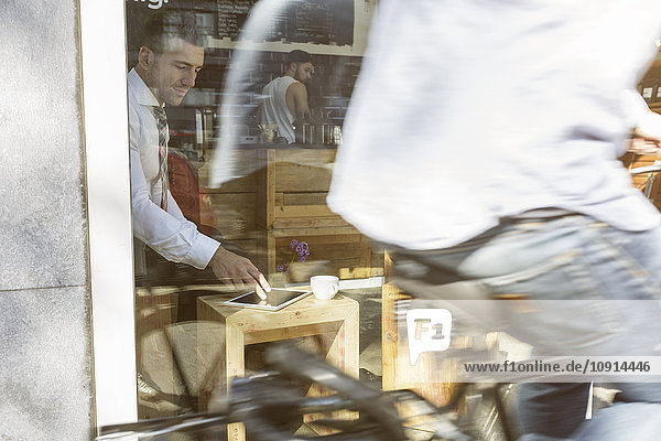 Geschäftsmann mit digitalem Tablett im Cafe