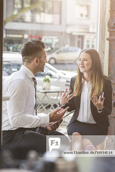 Businessman and businesswoman discussing in a cafe