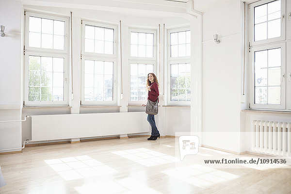 Woman looking around in empty apartment