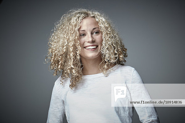 Porträt einer glücklichen blonden Frau mit lockigem Haar