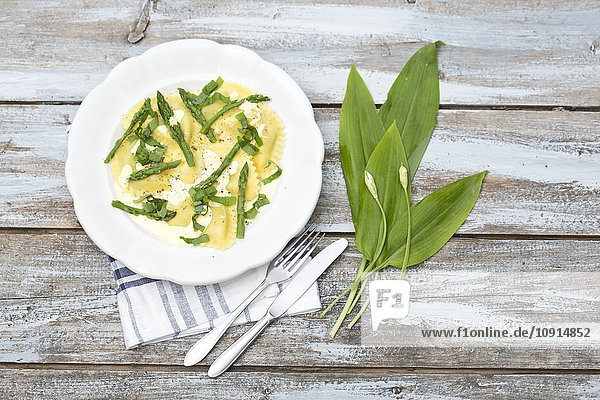 Ravioli gefüllt mit Spinat und Ricotta  grünen Spargelstangen und Sauce Hollandaise auf dem Teller
