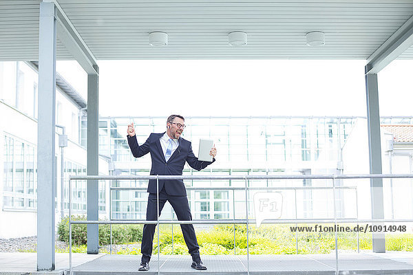 Enthusiastic businessman outside office building