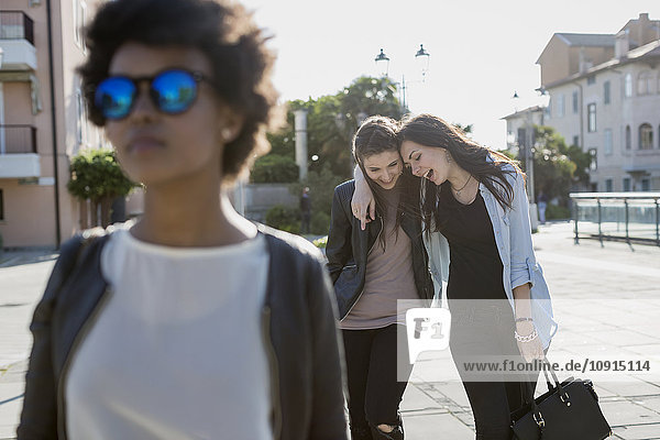 Young woman with sunglasses in the city with her friends