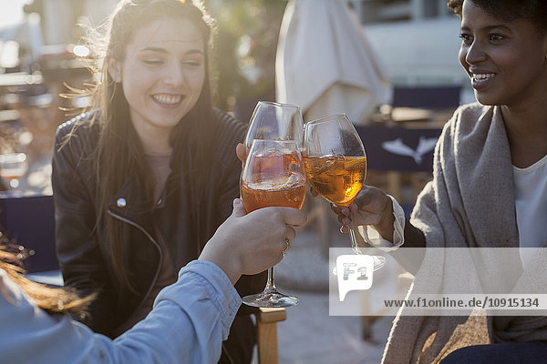 Junge Frauen sitzen in der Bar und trinken einen Aperitif.