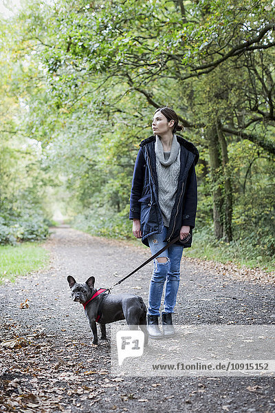 Frau  die mit dem Hund spazieren geht