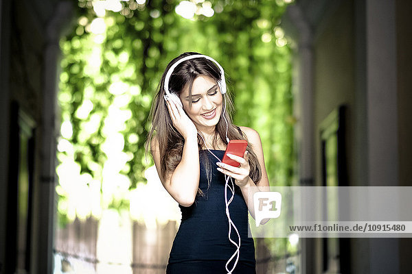 Junge Frau mit Kopfhörer und Smartphone