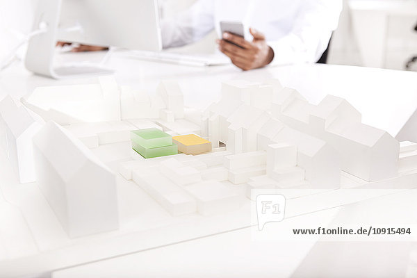 Architectural model on desk with working man in the background