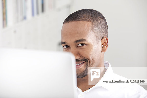 Portrait of smiling man behind his computer