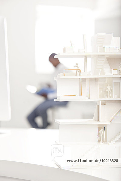 Architectural model on desk in an office with man in the background