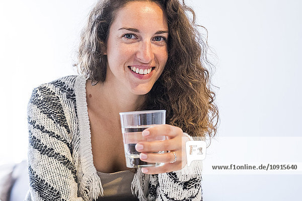 Porträt einer lächelnden Frau mit Wasserglas