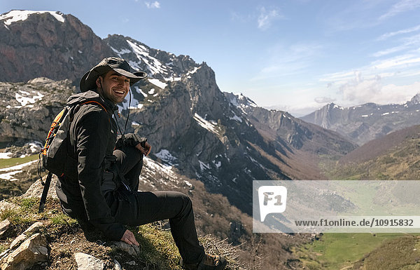 Spain  Asturias  Somiedo  happy man sitting on mountaintop