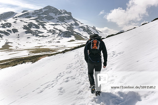 Spanien  Asturien  Somiedo  Mann beim Wandern in verschneiten Bergen