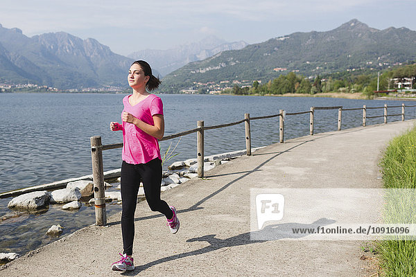 Italien Lecco junge Frau läuft am See entlang