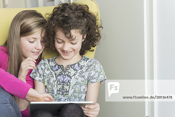Two girls using digital tablet