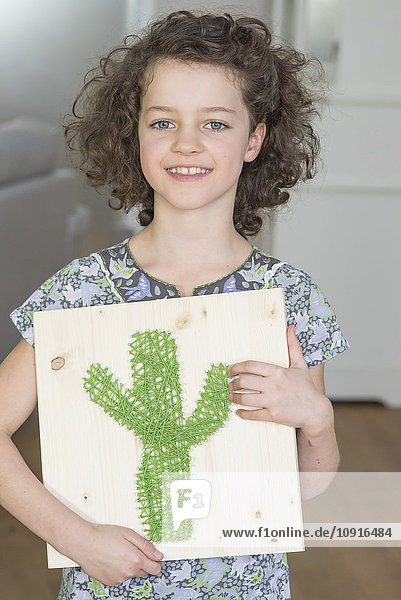 Mädchen hält Nagelbild mit Kaktus