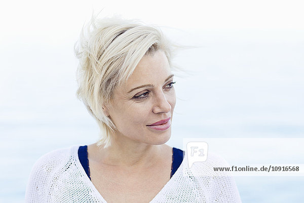 Porträt einer blonden Frau vor dem Meer
