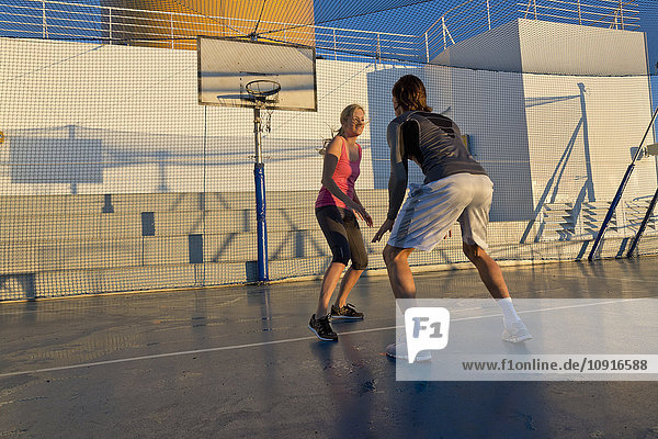 Ein Paar spielt Basketball auf dem Deck eines Kreuzfahrtschiffes.