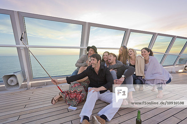 Group of friends taking selfies on a cruise