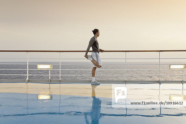 Young man doing exercises on a shipdeck  cruise ship  Mediteranean Sea