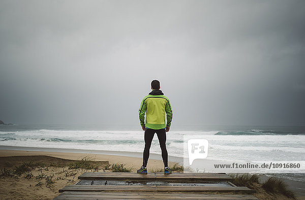 Jogger am Strand an einem stürmischen Tag  Valdovino  Galizien  Spanien.