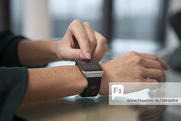 Smart watch on arm of mid adult woman