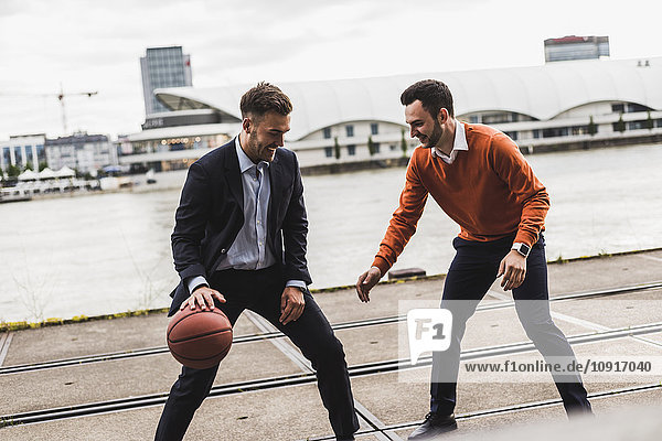 Zwei Kollegen spielen Basketball nach der Arbeit