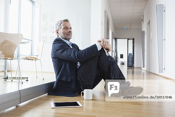 Successful businessman sitting on floor taking a break