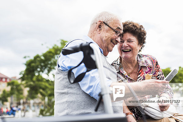 Seniorenpaar auf einer Bank sitzend  Spaß habend