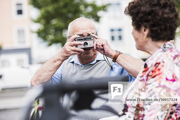 Senior man taking photo of his wife
