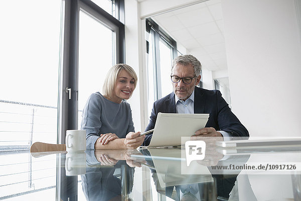 Businessman and woman working together in office discussing documents